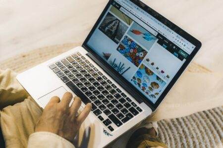 Le très haut débit, bientôt un droit opposable pour tous les Français ? A person using a laptop to browse stock photo websites. Freelancing work in a cozy setting.