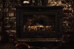 A warm and inviting vintage fireplace against a rustic brick wall, perfect for cozy winter settings.