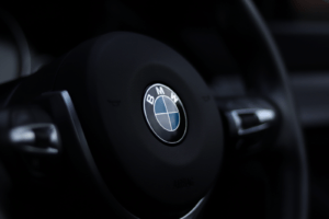 Bons plans et offres moto BMW : quand une promotion peut vraiment changer votre projet Detailed view of a BMW steering wheel emblem with a stylish depth of field effect.
