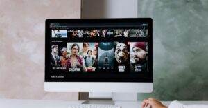 A modern workspace featuring a desktop screen displaying popular streaming series on Netflix.