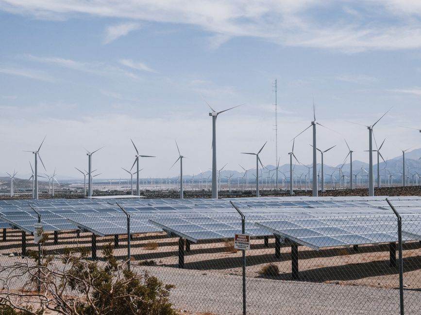 Nucléaire français et renouvelables allemandes : l’écart se resserre en juillet 2026 A renewable energy farm with wind turbines and solar panels under a clear sky.