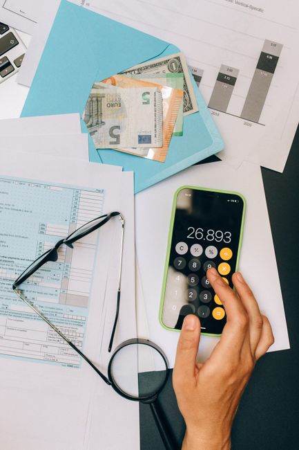 A top view of financial documents, calculator on smartphone, and euro notes, depicting business analysis.