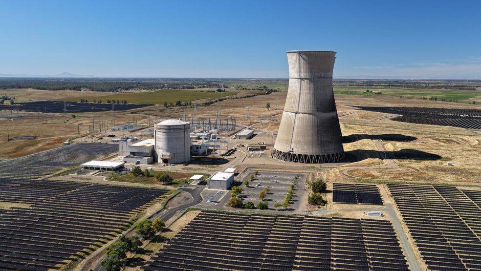 Aerial shot of Rancho Seco Solar Power Plant with large cooling tower and solar panels.
