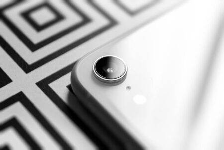 Pixel 11, 11 Pro, Pro XL et Fold : Tensor G6, HiLight et prix attendus en août 2026 Black and white close-up capturing the elegance of a smartphone camera lens against a geometric background.