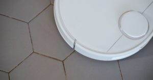 Close-up of a robotic vacuum cleaner on hexagonal tiles for efficient cleaning.