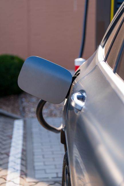 Close-up of an electric car being charged at a station. Sustainability and green technology.