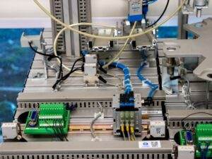 Close-up of industrial equipment showcasing electronic wiring and sensors in a manufacturing setup.