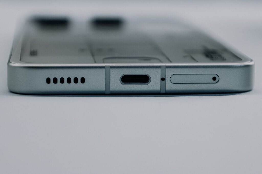 Detailed close-up of a smartphone's USB-C charging port and speaker grille, showcasing modern technology design.