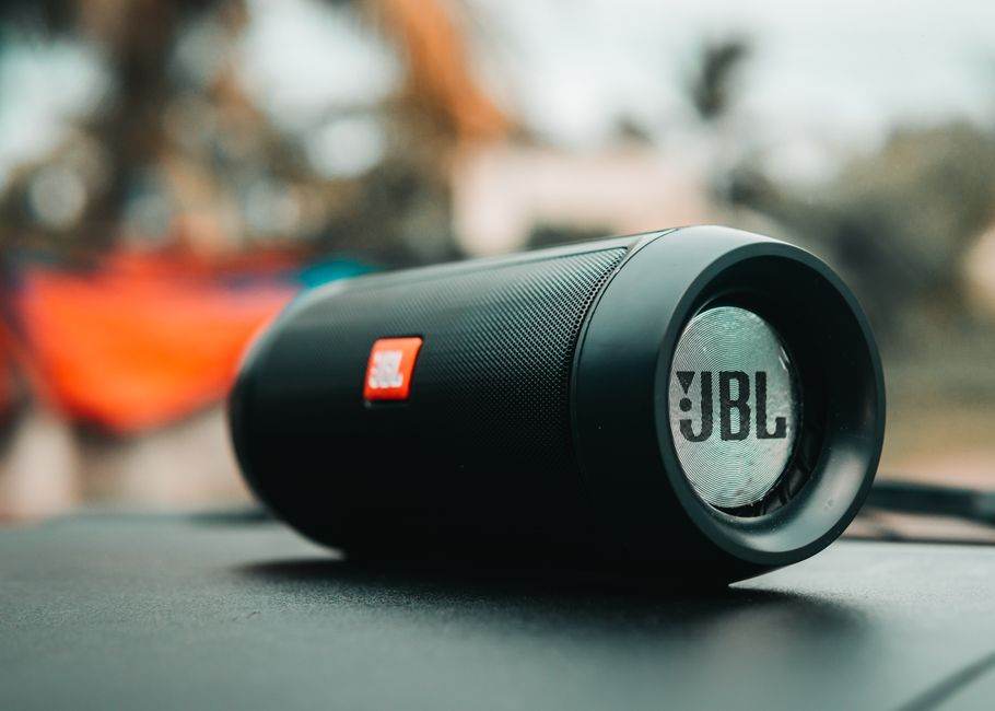 JBL Pulse 6 : IP68, USB-C et commandes physiques, mais une autonomie inchangée Focused shot of a black JBL portable speaker on a surface, ideal for technology concepts.