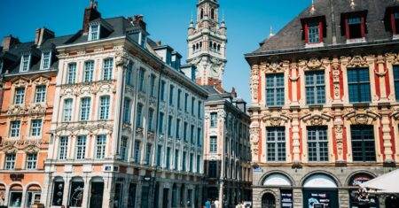 Voyages à Lille en 2026 : visites, itinéraire et agences Ornate townhouses and belfry in Lille's Grand Place on a sunny day, showcasing local landmarks.