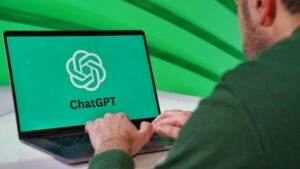 Person typing on a laptop displaying ChatGPT logo with a green vibrant setting.