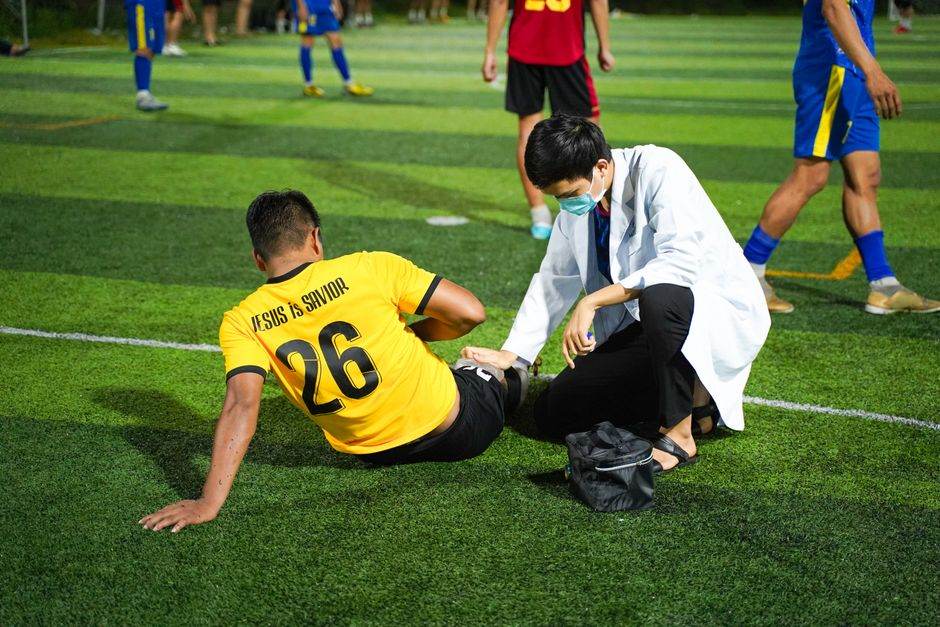 Soccer player receiving medical aid on the field for injury during a match.