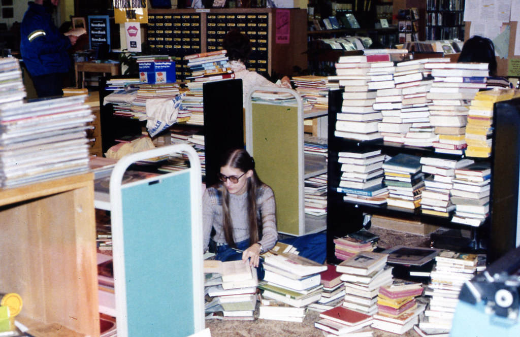 Unknown staff person checking in book at the Emily Fowler Library, ca1977