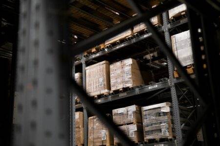 Stockage automatisé en atelier : la fin du chaos dans les rayonnages ? a warehouse filled with lots of boxes and pallets