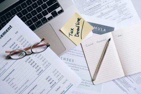 Fuite des impôts 2026 : 678 437 dossiers, une alerte non confirmée Workspace with laptop, documents, and tax deadline note for financial management.