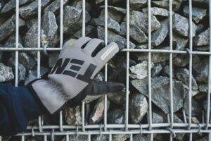 a person holding a glove over a pile of rocks