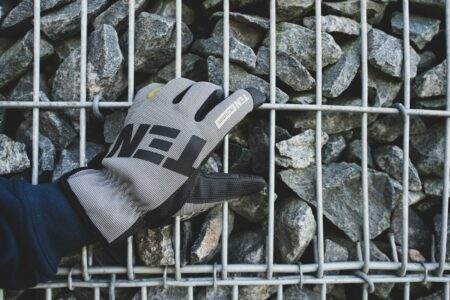 Distributeur automatique EPI : pourquoi vos gants disparaissent (et comment y remédier) a person holding a glove over a pile of rocks
