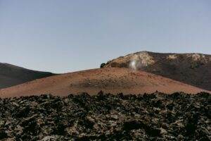 A breathtaking view of a barren volcanic landscape with rugged rocky terrain under clear skies.