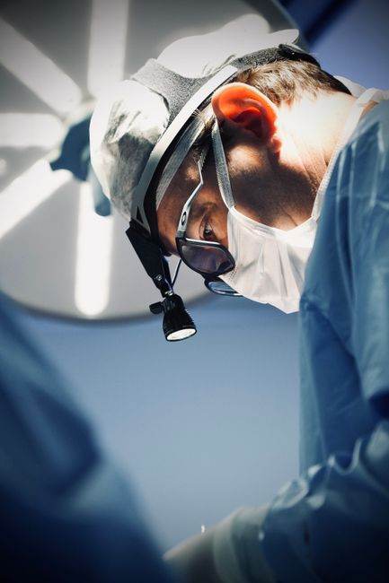 Close-up of a focused surgeon in an operating room with surgical equipment.