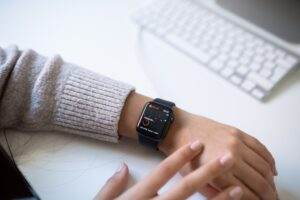 Close-up of a person checking health stats on a smartwatch in an office environment.