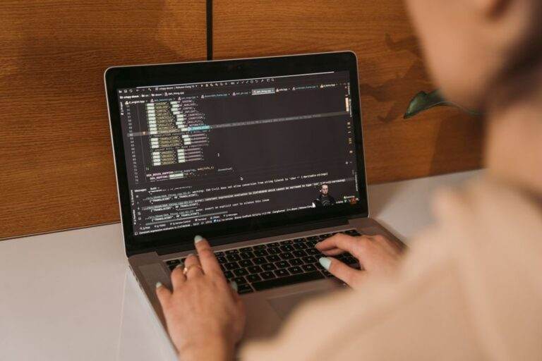 Claude Fable 5.1 : le cache baisse, l’accès reste filtré Close-up of a woman coding using a laptop in an office environment, showcasing modern technology.