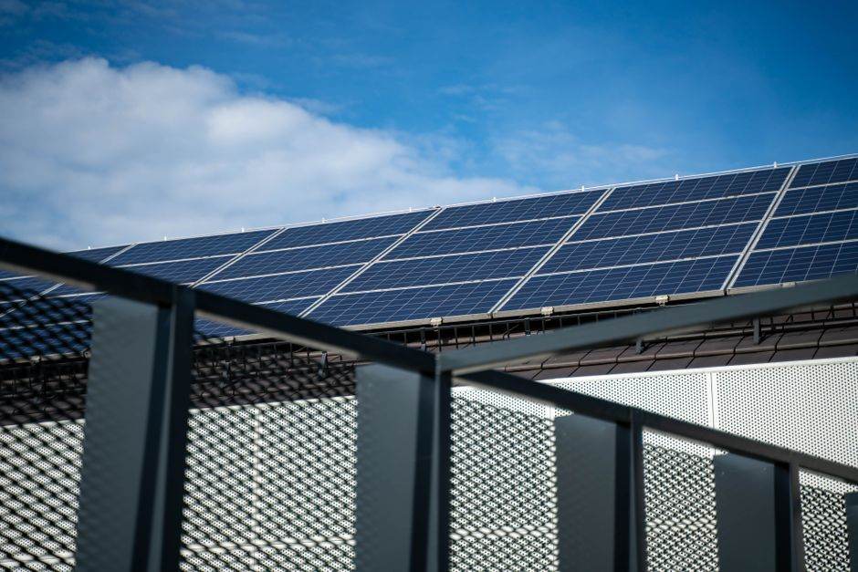 À Tres Cantos, un revêtement affiche 12,9 °C de moins qu’un témoin Close-up view of modern solar panels on a rooftop against a clear blue sky, representing clean energy.