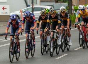 Group of cyclists racing on city streets during a competitive cycling event.