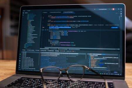 Logiciels open source en 2026 : choisir sans illusion Laptop screen showing debugging software with code, perfect for tech and software development themes.