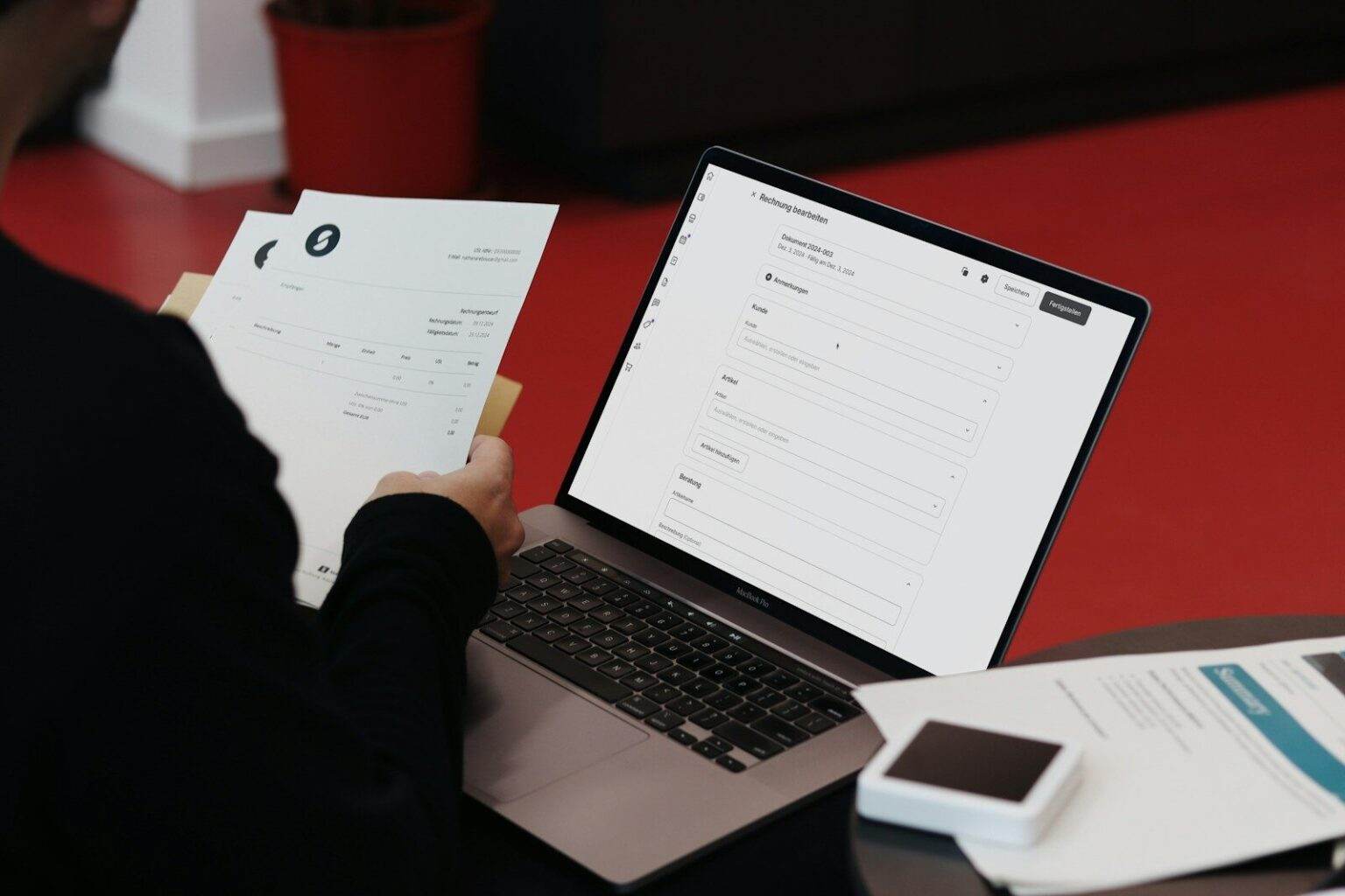 Comment réduire les erreurs dans le traitement des factures fournisseurs ? A person sitting at a desk with a laptop and papers