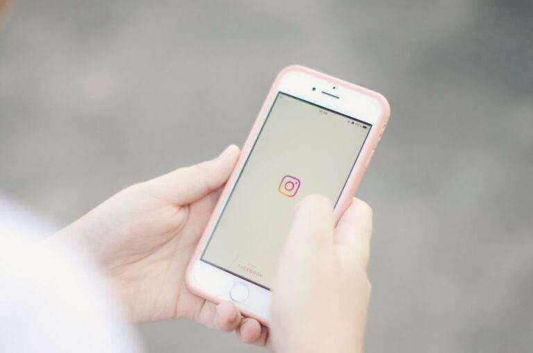 Clavier iPhone : 9 gestes et réglages utiles Hands holding a smartphone with the Instagram app open on the screen.