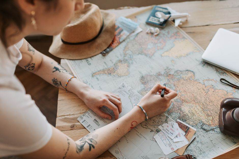 Google Maps et My Maps : la carte ne fait pas le trajet Person planning a journey with a map, passport, and travel essentials on a wooden table.